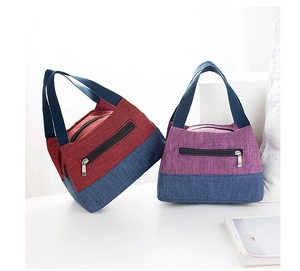 Detail of color-block canvas lunch bags featuring red, purple, and navy with sturdy zippers