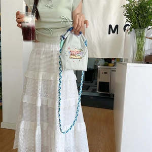 Detailed embroidery carousel pattern and braided handles on light blue oxford fabric bag