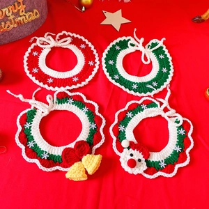 Detail of hand-knitted Christmas pet collar with festive snowflake and bell accessories