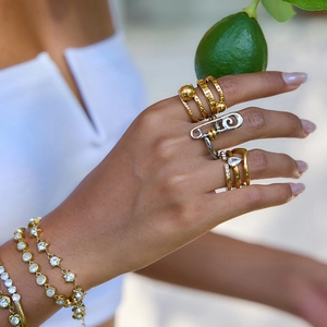 Classic 18K gold plated stainless steel rings and diamond bracelets set on a model