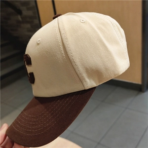 Detail view of cream canvas baseball cap with brown brim and C letter embroidery