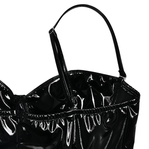 Détails des bretelles réglables et de la texture en similicuir brillant sur la robe noire