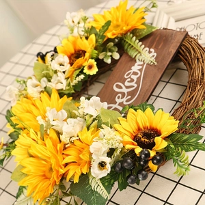 Dettaglio di ghirlanda di girasoli con targa Welcome in legno su base in rattan