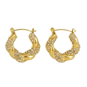Macro detail of 18k gold plated twisted hoop earrings with sparkling zircon inlay