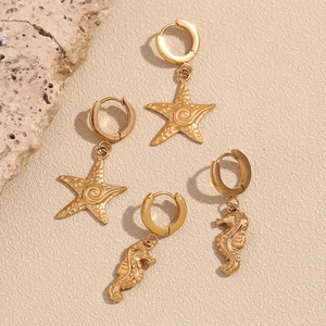 Detail of 18K gold plated hoop earrings with sea star and seahorse charms