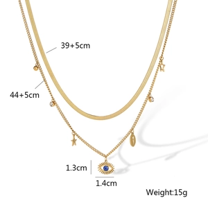 Close-up of gold layered necklace featuring flat snake chain and blue evil eye pendant