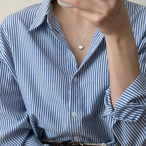 Close-up of minimalist S925 sterling silver heart pendant necklace on a model
