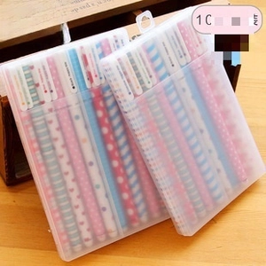 Macro detail of clear plastic pen cases with patterned gel pens on a wooden surface