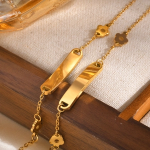 Elegant gold stainless steel flower chain bracelet with engraved metal plates on wood