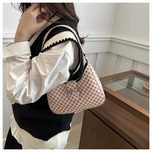 Detail of pink vintage monogram hobo bag with silver bow buckle on model shoulder