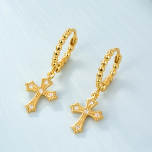 Macro detail of S925 sterling silver gold earrings with zircon cross and bead texture