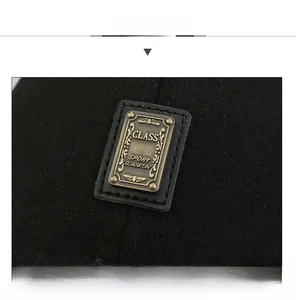 Detailed close-up of a black winter hat with a vintage metal emblem on leather base