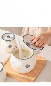 Ceramic lard jar detail with a slotted lid, ceramic spoon, and minimalist kitchen graphics