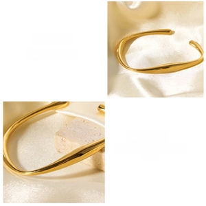 Detail of a polished gold-plated stainless steel cuff with unique organic wavy design