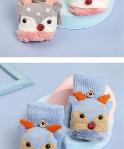 Detail of kids knitted deer flip-top gloves with plush cuffs and button closure
