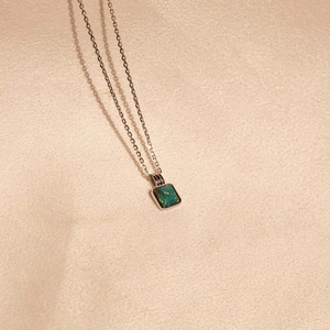 Macro detail of rectangle green opal pendant with vibrant fire and silver chain