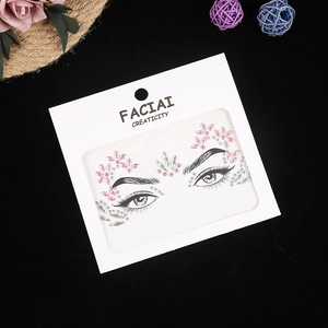Close-up of floral pink and iridescent acrylic face rhinestones on white display card