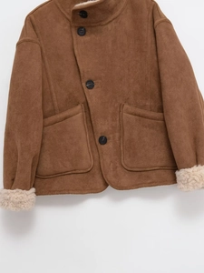 Gros plan sur une veste en daim marron avec doublure polaire et détails de boutons