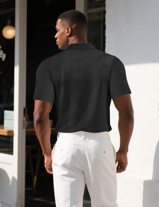 Outdoor back view of man wearing a premium black knit polo shirt in a cafe setting