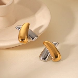 Macro view of crossover X-shape stud earrings in polished gold and silver two-tone finish