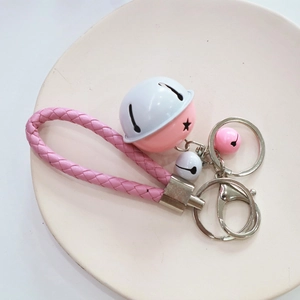Pink and white woven leather keychain with star cutout bells and silver metal clasp