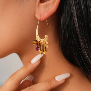 Boucles d'oreilles bohèmes plaquées or 18k avec perles de pierre sur un mannequin