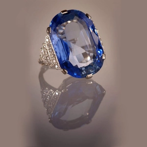 Dettaglio anello con topazio blu ovale e pavé di diamanti su fascia a gradini chic