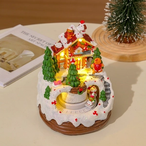 Detail of a lighted Christmas candy shop gingerbread house with snow and miniature figurines