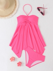 Flat lay of pink halter tankini with ribbed texture and beach vacation accessories