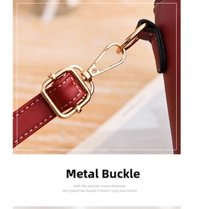 Macro shot of gold swivel clasp and precise stitching on the burgundy shoulder bag strap