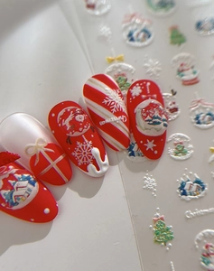 Macro shot of 3D embossed Christmas nail stickers with snowflake and reindeer patterns