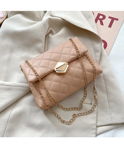 Detail of beige quilted shoulder bag with geometric metal clasp and gold chain strap