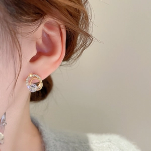 Detail view of gold-plated hoop earrings with sparkling zircon stones worn by a model