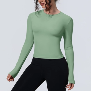 Détail du haut de yoga vert sauge ajusté avec tissu extensible évacuant l'humidité