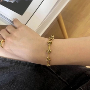 Bracelet chaîne à nœud minimaliste en acier titane plaqué or 18 carats au poignet