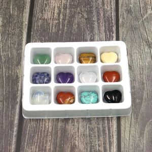 Detailed top view of 12 assorted heart-shaped polished natural stones in a display tray