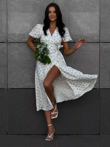 Detail of white floral cotton wrap dress with puffy sleeves and side slit design