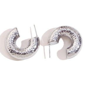Polished silver C-shaped chunky hoop earrings with textured hammered finish on white background