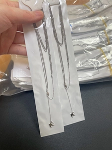 Détail de colliers multicouches en acier inoxydable avec pendentifs hirondelle en argent