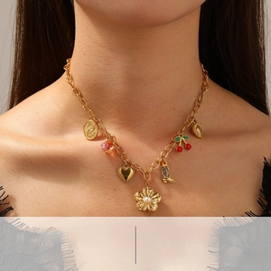 Detail of gold-plated chain necklace with cherry, rose, and pearl flower charms