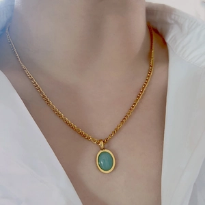 Titanium butterfly heart necklace with green gem pendant on model neck