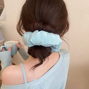 Blue fabric scrunchie bun hair tie accessory on model for a stylish daily hairstyle