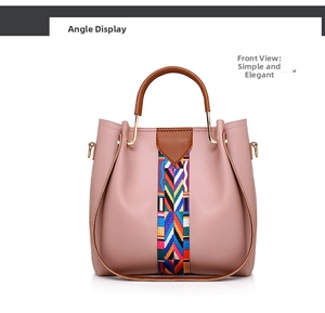 Close-up of pink leather bucket bag with colorful woven strap and gold metal hardware