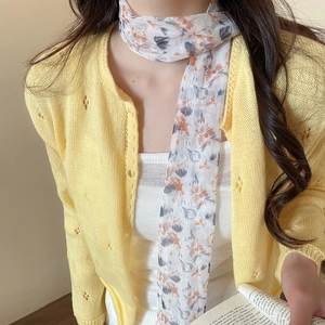 Detail of pastoral floral mesh scarf necklace worn with a yellow cardigan lifestyle shot