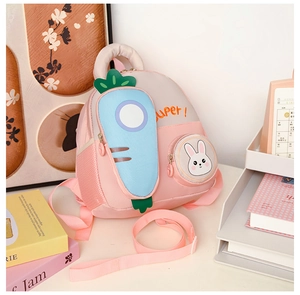 Close-up of pink toddler backpack with blue carrot pocket and rabbit coin purse detail