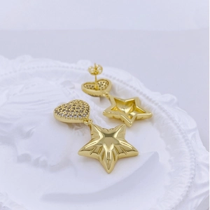 Macro shot of gold heart stud with sparkling cubic zirconia and star pendant details