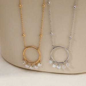Minimalist ring necklaces in gold and silver with five zircon pendants on warm stone