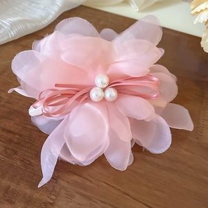 Detailed view of pink silk flower hair claw clip with three decorative pearls