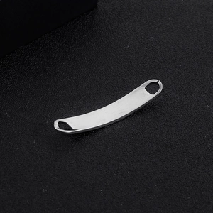 Macro detail of curved stainless steel connector bar with dual holes for DIY jewelry