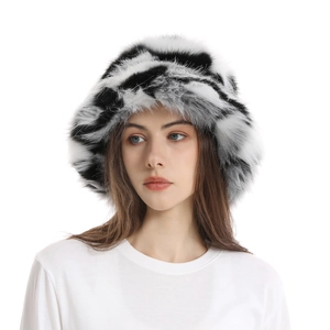 Close-up of black and white cow print faux fur bucket hat on a model for winter style